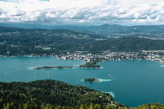 Lake Wörthersee from above with sailboats, small islands and lakeside villages