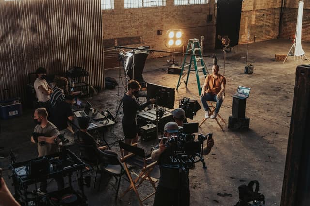 Film crew lighting and recording an interview in a studio