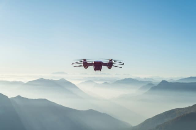 Drone flying above misty mountain ranges