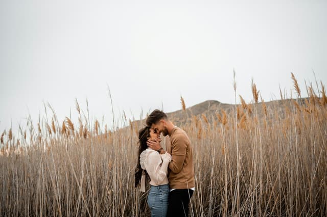 Couple embracing in a field of tall grass