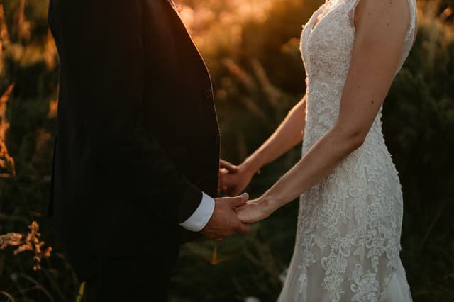 Bride and groom holding hands in warm evening light