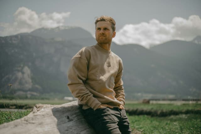 Traveller sitting outdoors with mountains in the background