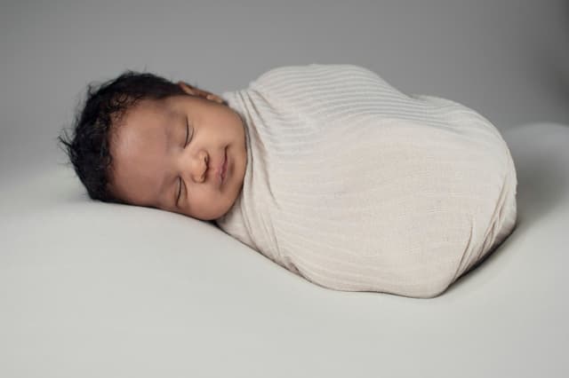 Sleeping newborn baby wrapped in a blanket