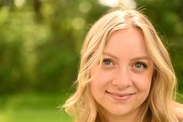 Close-up portrait of a smiling woman against soft green background